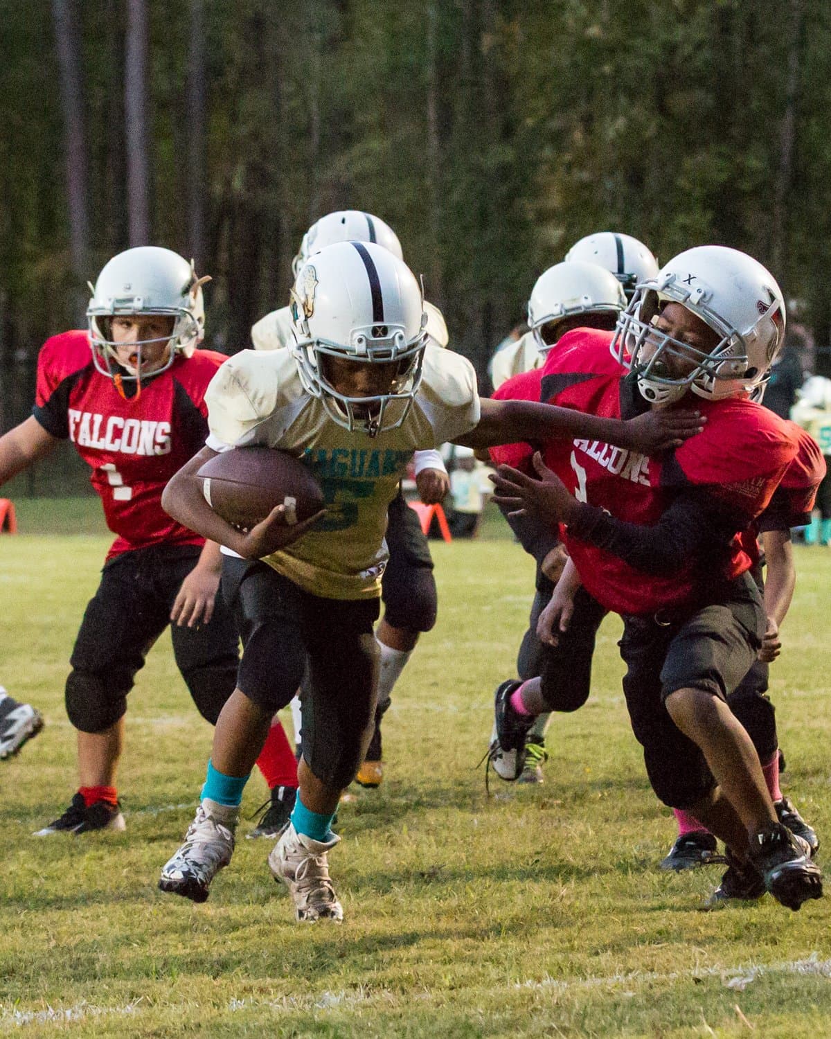 North Charleston youth tackle football — ball carrier wrapped up by two defenders